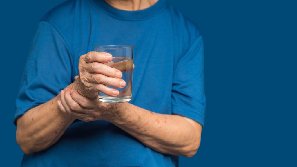 Close-up,Of,Hands,Senior,Woman,Trying,To,Hold,A,Glass