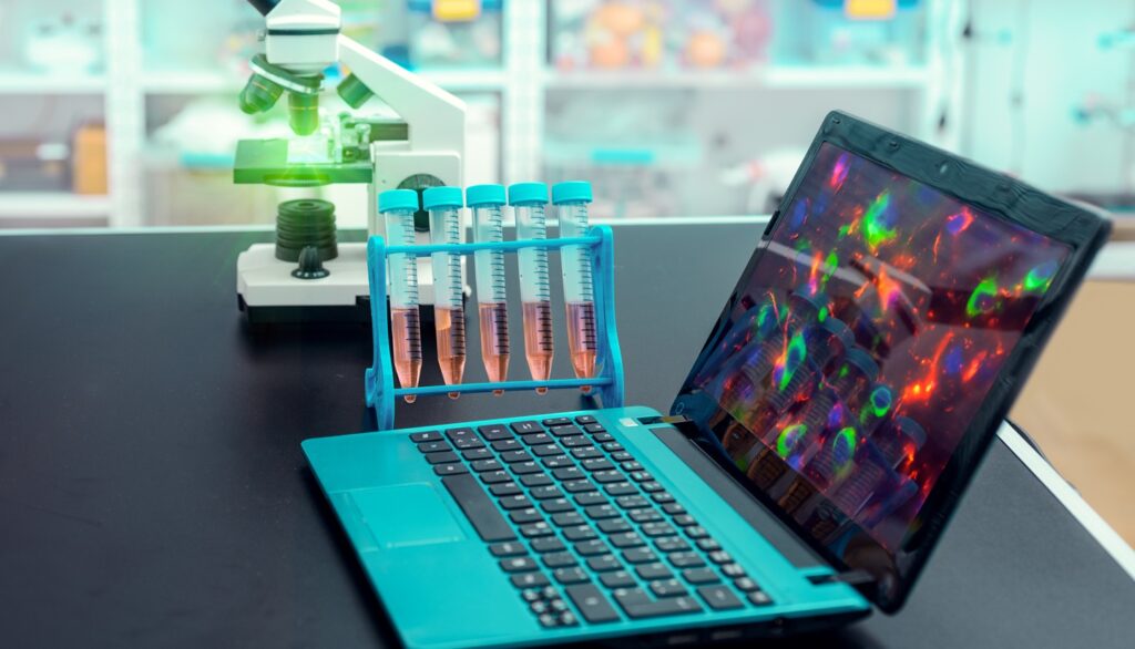 Microscope,And,Portable,Computer,With,Microscopic,Image,On,Observation,Table,