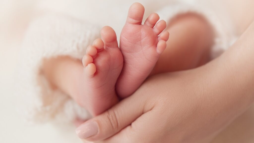 Baby,Feet,In,Mother,Hands.,Newborn,Toes,Close,Up,Over