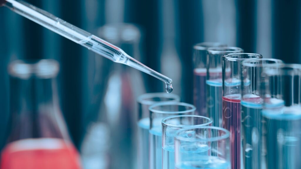 Researcher,With,Glass,Laboratory,Chemical,Test,Tubes,With,Liquid,For