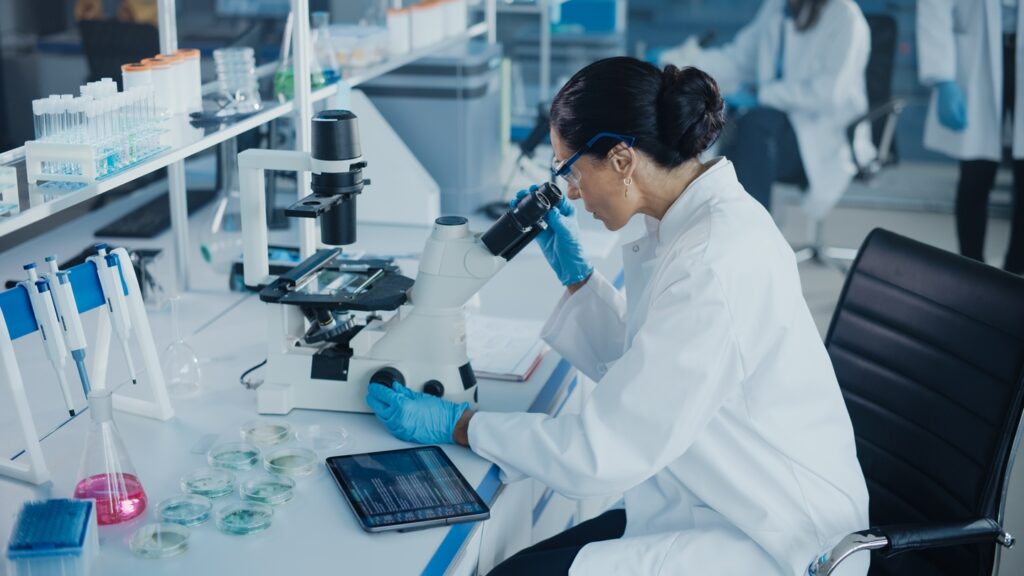 Medical,Development,Laboratory:,Caucasian,Female,Scientist,Looking,Under,Microscope,,Analyzing